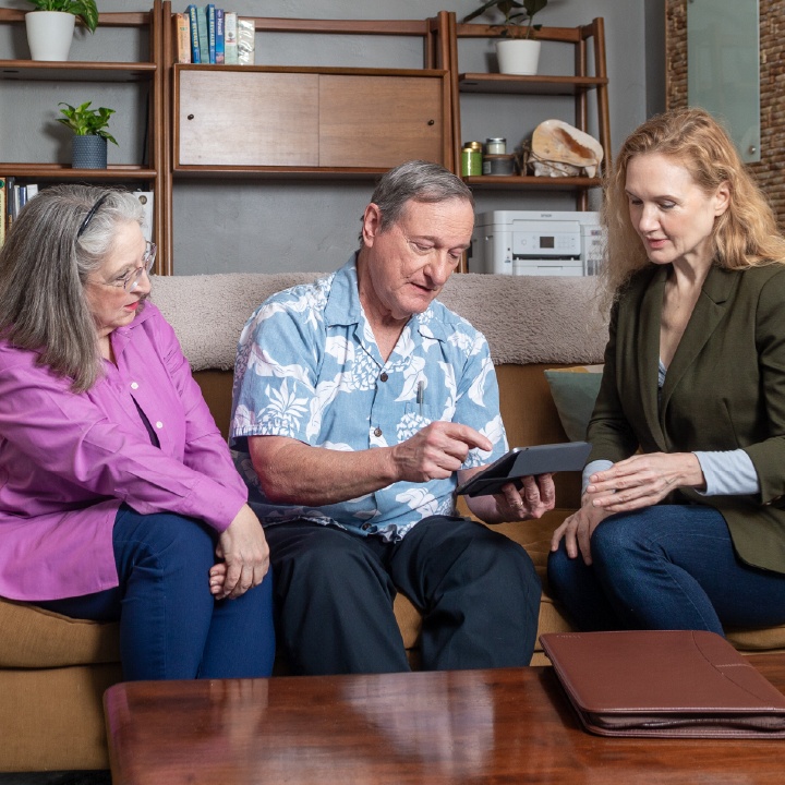 A financial professional sits with a married couple explaining how life insurance could help with estate planning.