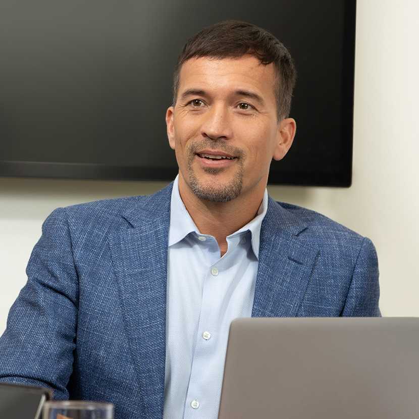 A businessman sitting at a laptop reviews TruStage life insurance partnership options.